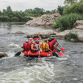 Group of men and women enjoy water rafting activity